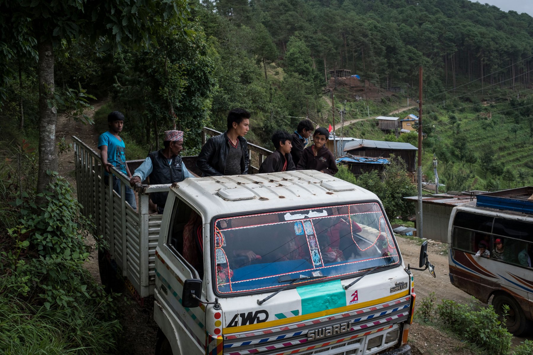 Men travel in the back of a truck out of Chaubas, Kavre district, Nepal.