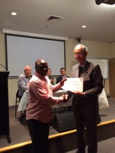 visiting scientist and PhD candidate Kenneth Mbene receiving certificate from SA Committee Chair John Radcliffe 